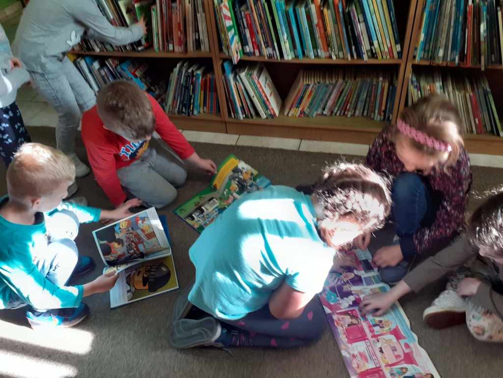 Dzieci ze SP Nr 7 czytające bajki na dywanie w Filii Nr 4 - powiększenie