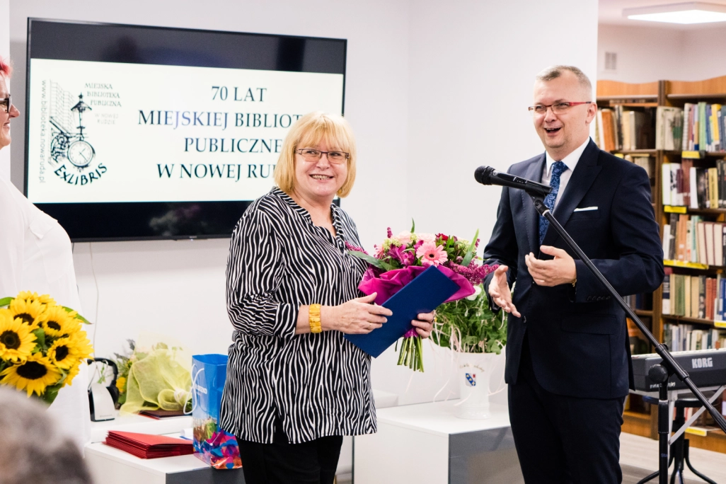 Dyrektor Biblioteki odbiera kwiaty od jednego z uczestników jubileuszu - powiększenie