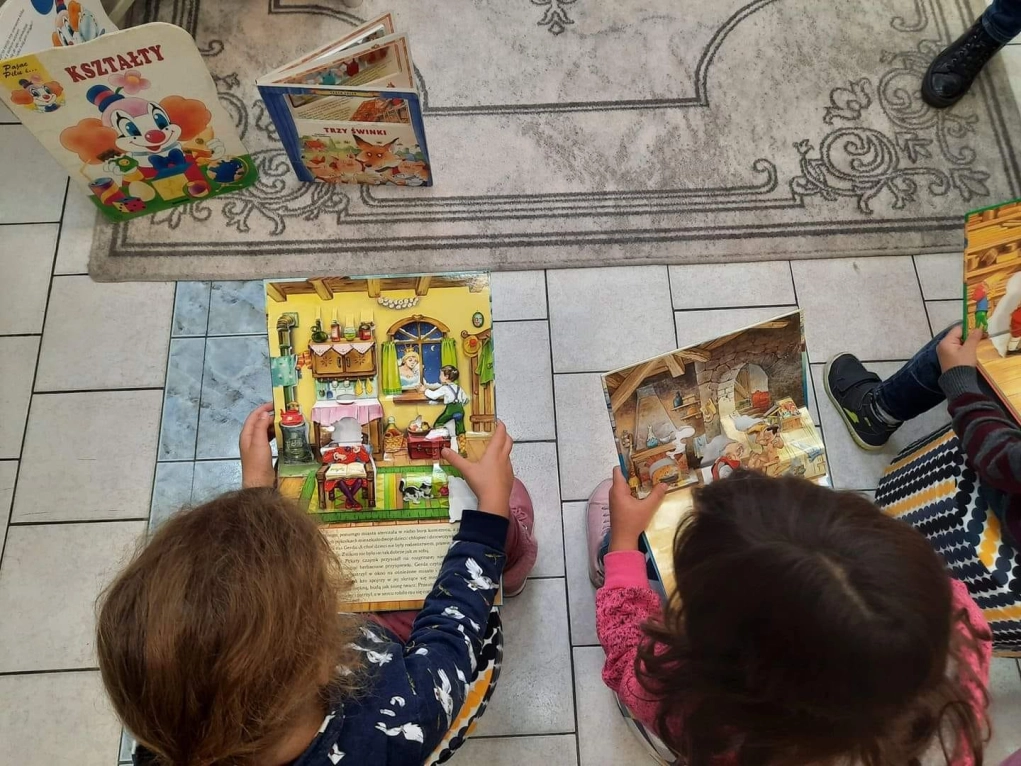 Uczniowie oglądający rozkładane, trójwymiarowe książki dla najmłodszych - powiększenie