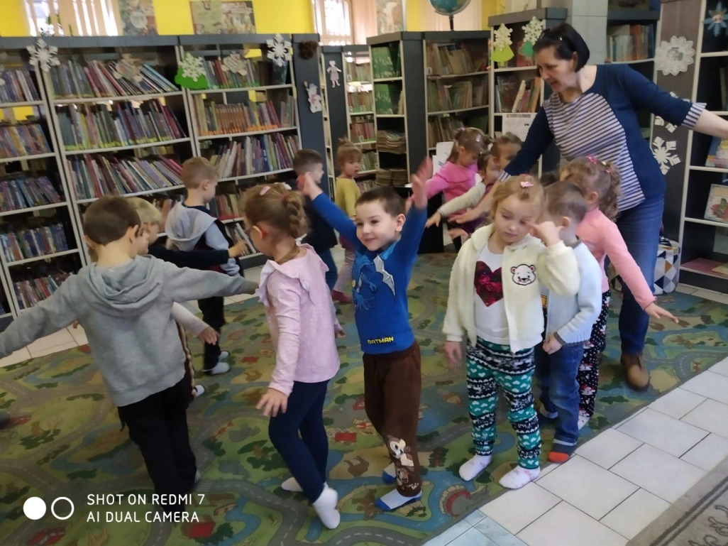 Przedszkolaki i prowadząca zajęcia podczas wspólnej zabawy na dywanie - powiększenie