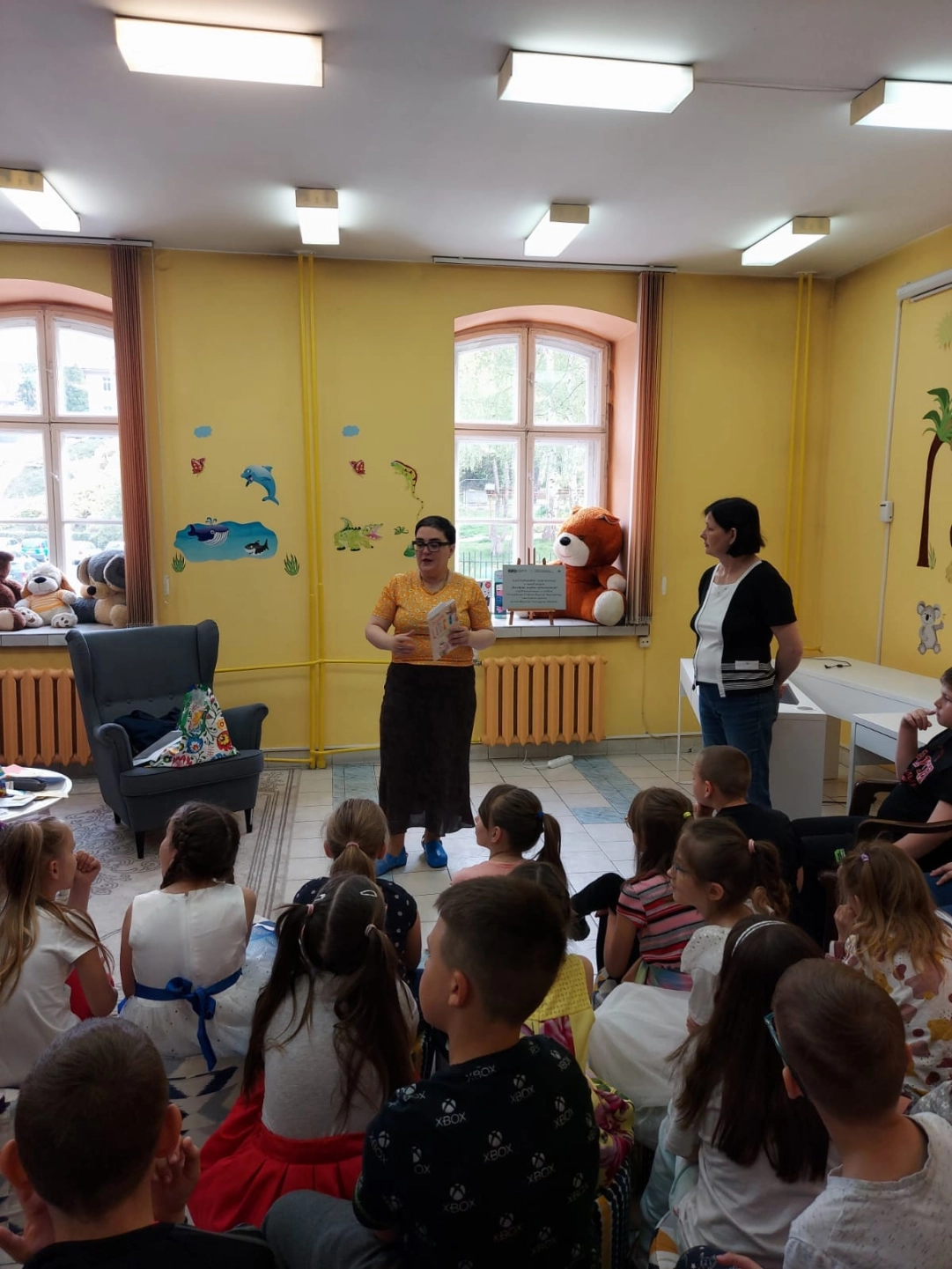 Agnieszka Urbańska mówi do siedzących w Oddziale dla Dzieci uczniów - powiększenie