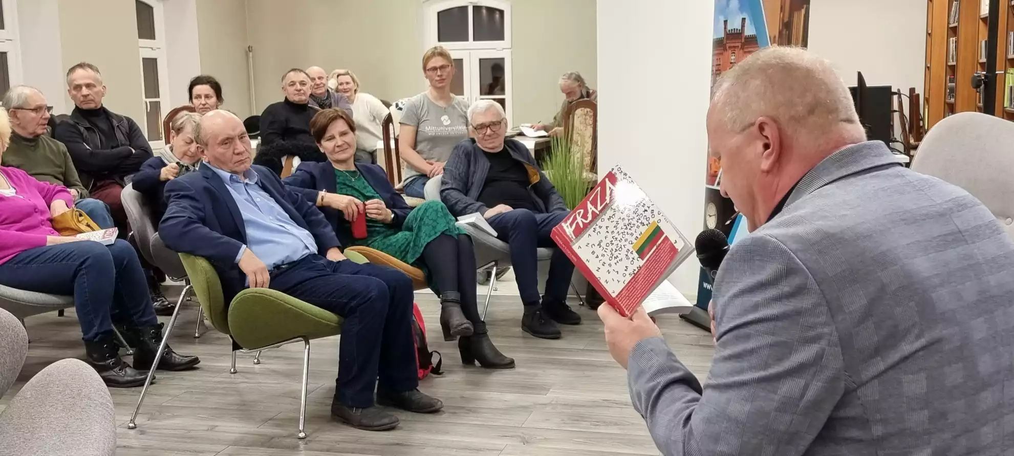 Prowadzący spotkanie Karol Maliszewski czyta fragment pisma literacko-artystycznego. - powiększenie