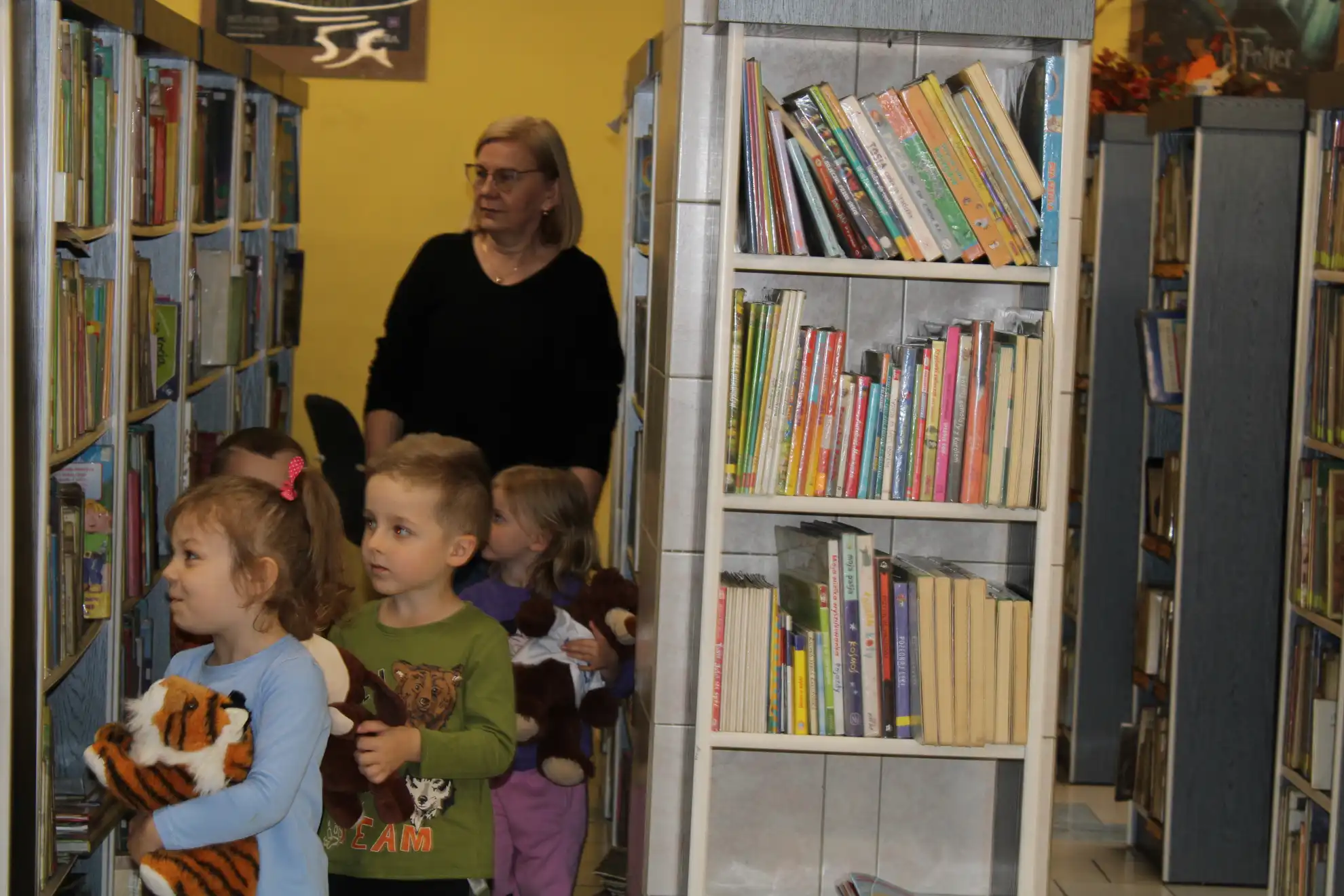 Dzieci spacerują między regałami.  - powiększenie