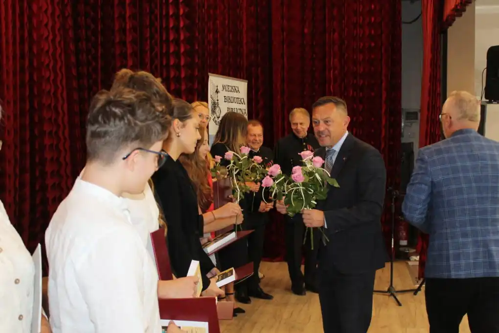 Burmistrz Nowej Rudy Tomasz Kiliński wręcza kwiaty uczestnikom wydarzenia. - powiększenie