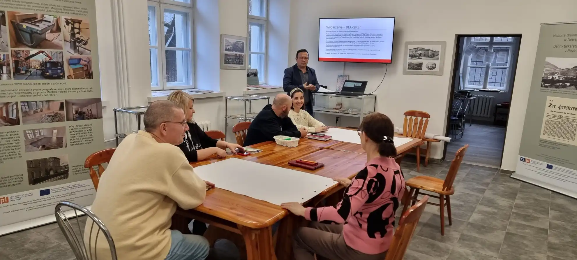 Grupa bibliotekarzy siedzi przy stole w trakcie szkolenia. - powiększenie