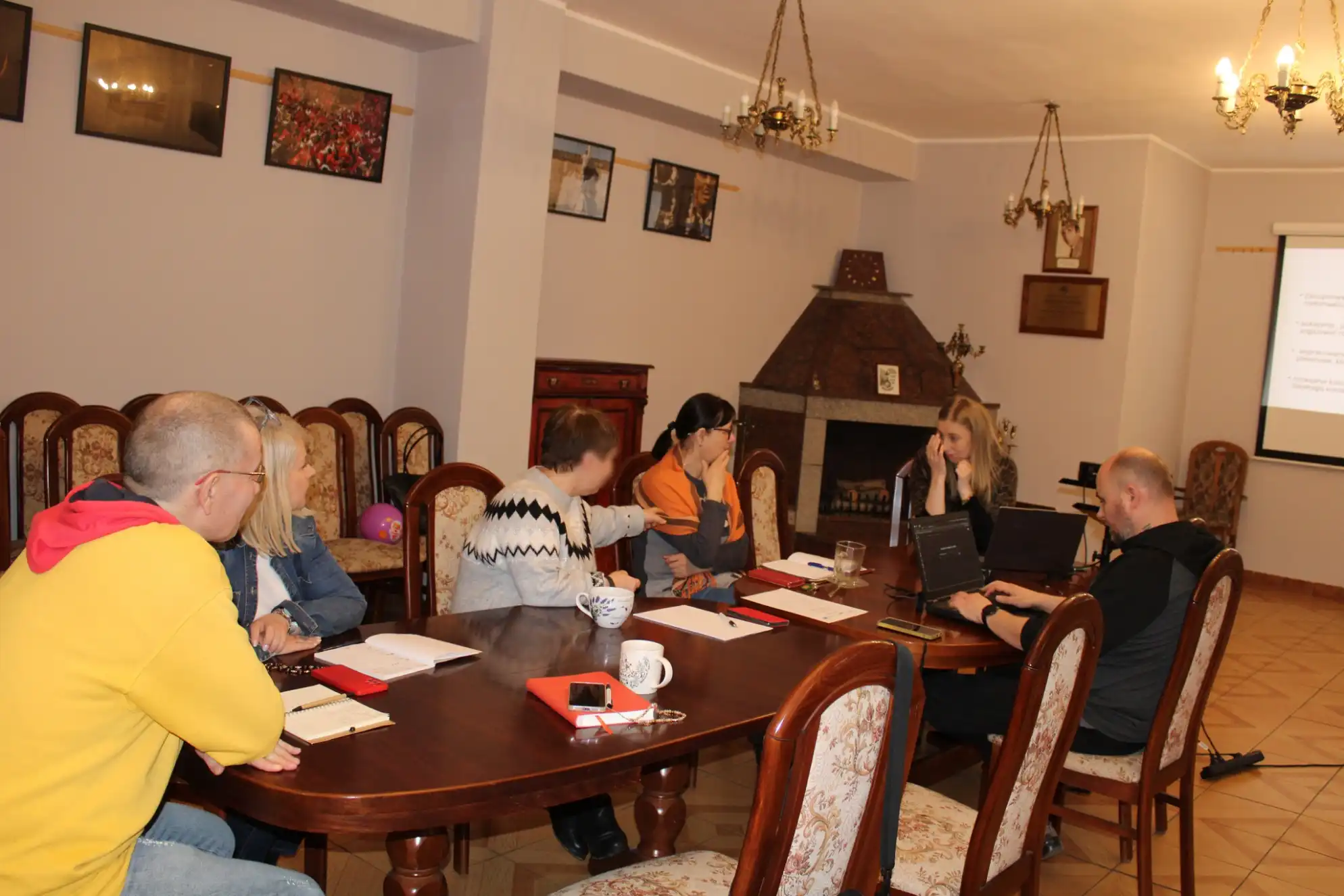 pracownicy biblioteki i prowadzący szkolenie siedzą przy stole w Sali Kominkowej MBP. - powiększenie