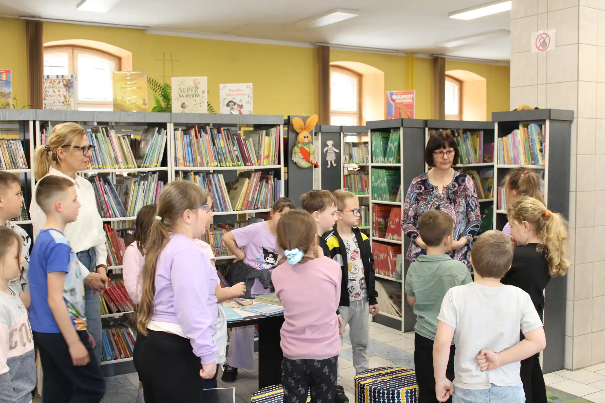 Grupa dzieci składa życzenia panie bibliotekarce z okazji Światowego Dnia Książki. - powiększenie