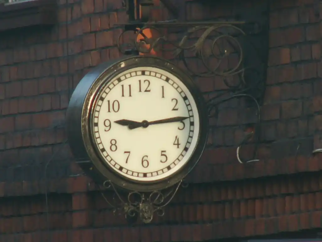 Zegar na ścianie, nad drzwiami wejściowymi do biblioteki