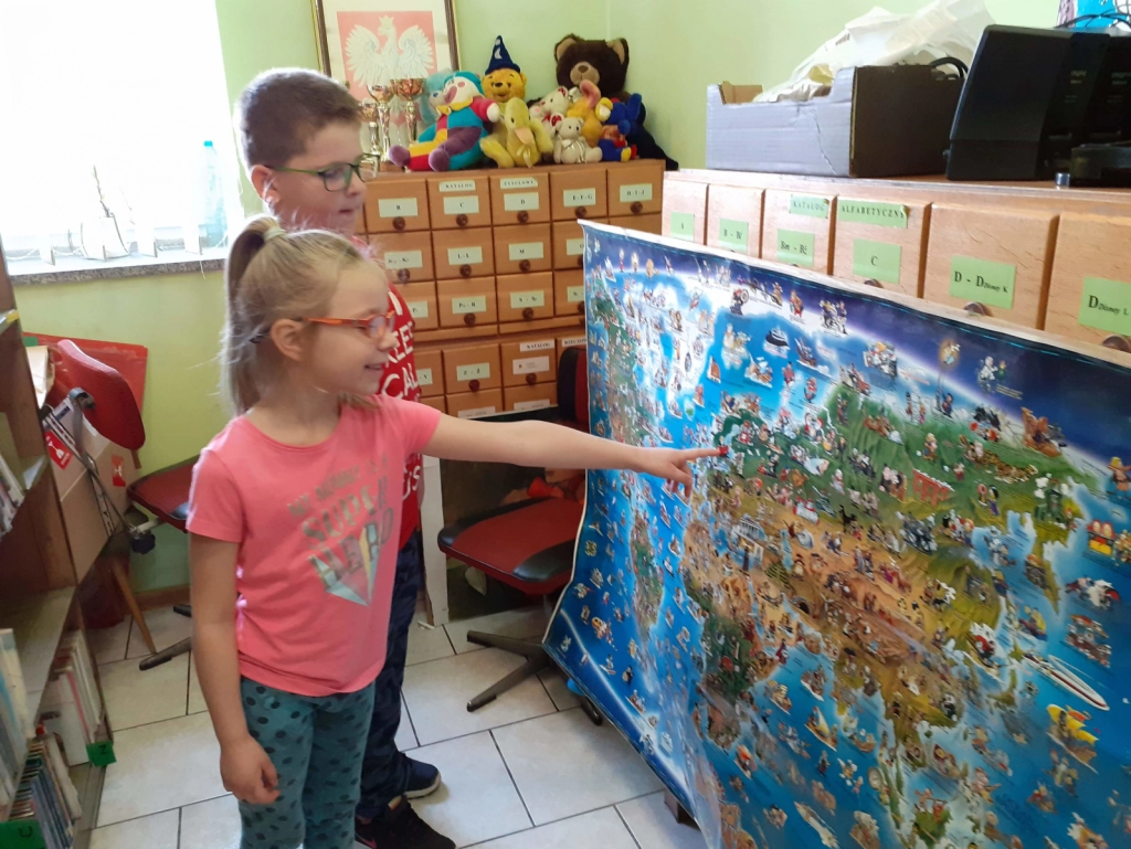 Dzieci ze SP Nr 7 stojące przed mapą świata w Filii Nr 4
