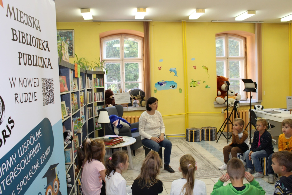Grupa uczniów słucha prowadzącej zajęcia Małgorzaty Ciechanowskiej