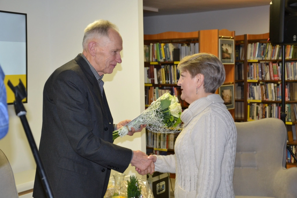 Antoni Matuszkiewicz odbiera kwiaty i gratulacje od uczestniczki spotkania