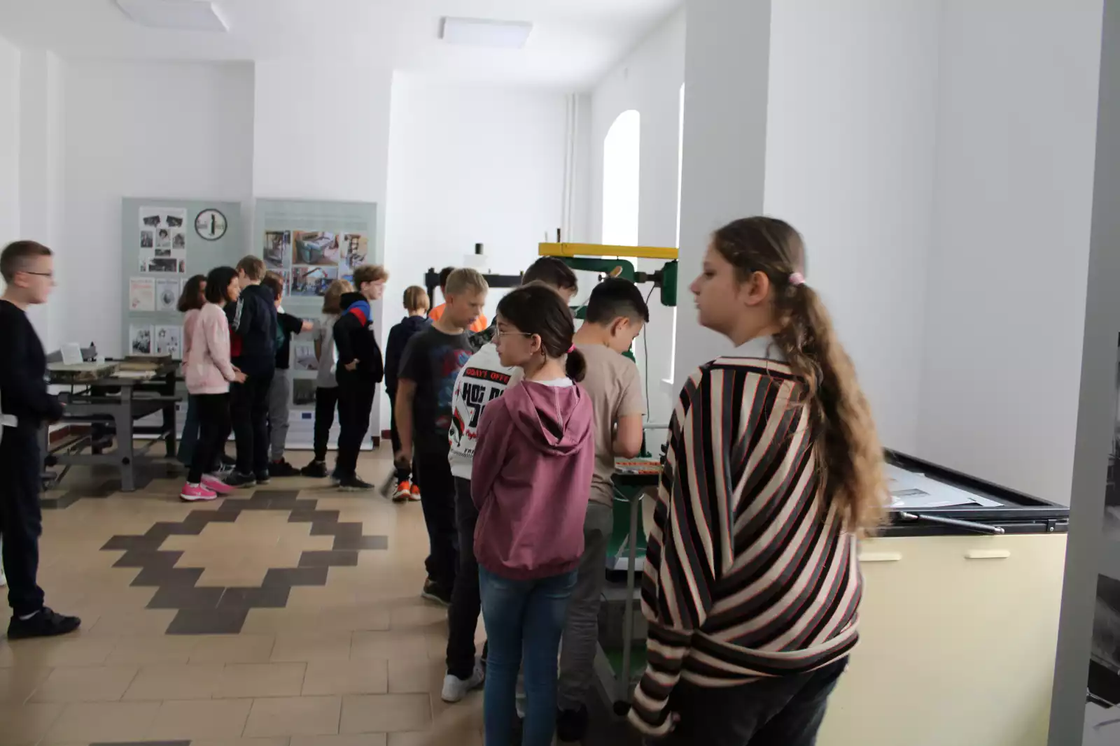 Uczniowie stoją przy maszynach poligraficznych