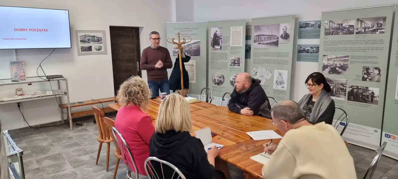 Pracownicy biblioteki siedzą przy stole podczas trwania szkolenia